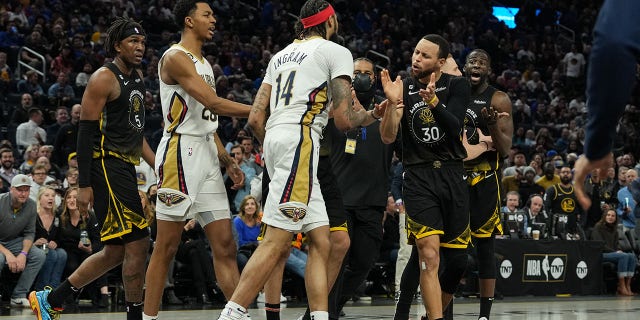 Stephen Curry #30 and Draymond Green #23 of the Golden State Warriors talk to Brandon Ingram #14 of the New Orleans Pelicans following a scuffle during the second quarter at Chase Center on March 28, 2023 in San Francisco, California.