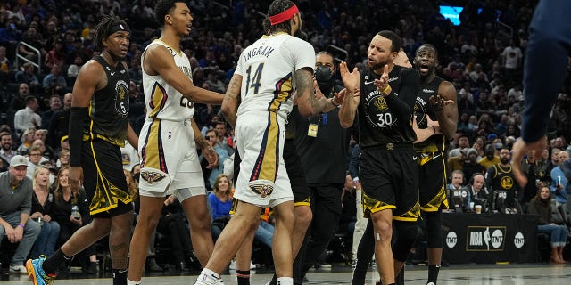 Stephen Curry #30 and Draymond Green #23 of the Golden State Warriors talk with Brandon Ingram #14 of the New Orleans Pelicans after a fight during the second quarter at the Chase Center on March 28, 2023 in San Francisco, California.