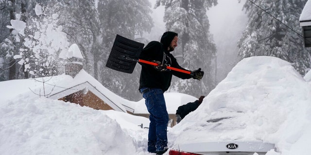 Kenny Rybak, 31, shovels snow around his car in Running Springs, California, Tuesday, Feb. 28, 2023. 