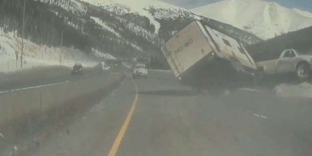 A pickup truck hauling a camper trailer spun out on I-70 near Denver.