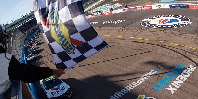 William Byron, driver of the #24 Chevrolet Valvoline, takes the checkered flag to win the NASCAR Cup Series United Rentals Work United 500 at Phoenix Raceway on March 12, 2023 in Avondale, Arizona.