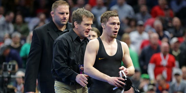 Spencer Lee of the Iowa Hawkeyes is congratulated by assistant head coach Terry Brands after winning their first-place game during the NCAA sixth session.
