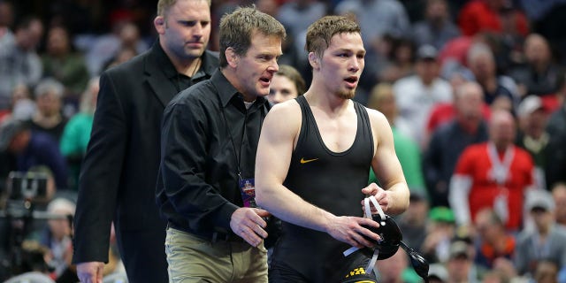 Spencer Lee de los Iowa Hawkeyes es felicitado por el entrenador en jefe asistente Terry Brands después de ganar su juego por el primer lugar en la Ronda 6 de la NCAA.