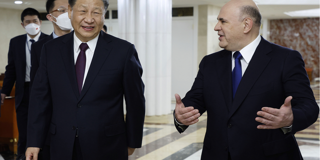 Russian Prime Minister Mikhail Mishustin, right, speaks with Chinese President Xi Jinping during their meeting in Moscow on Tuesday, March 21.