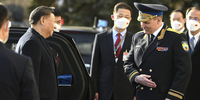 Chinese President Xi Jinping, left, is welcomed by Commandant of the Moscow Kremlin Sergei Udovenko as he arrives for the meeting with Russian President Vladimir Putin.