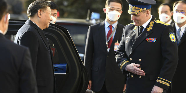 Chinese President Xi Jinping, left, is welcomed by Commandant of the Moscow Kremlin Sergei Udovenko as he arrives for the meeting with Russian President Vladimir Putin.