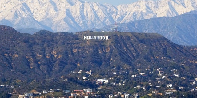 Tanda Hollywood terlihat dengan pegunungan yang tertutup salju di belakangnya dari kawasan Baldwin Hills di Los Angeles, Kamis, 2 Maret 2023.