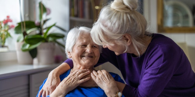 Woman hugging her elderly mother