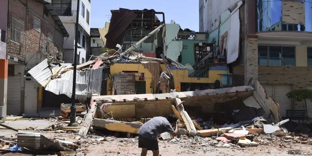 A man takes a photo of a collapsed building after an earthquake rocked Machala, Ecuador on Saturday, March 18, 2023.