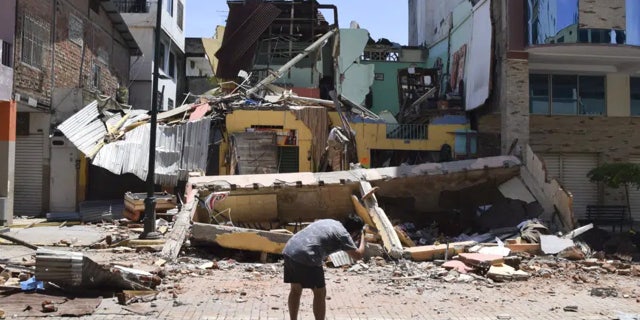 Fuerte sismo deja 14 muertos en Ecuador y 1 en Perú 4 Un hombre toma una foto de un edificio que se derrumbó después de que un terremoto sacudiera Machala, Ecuador, el sábado 18 de marzo de 2023.