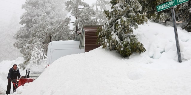 Richard Pelayo clears snow from his driveway after a series of winter storms dropped more than 100 inches of snow in the San Bernardino Mountains in Southern California on March 6, 2023, near Twin Peaks, California. 