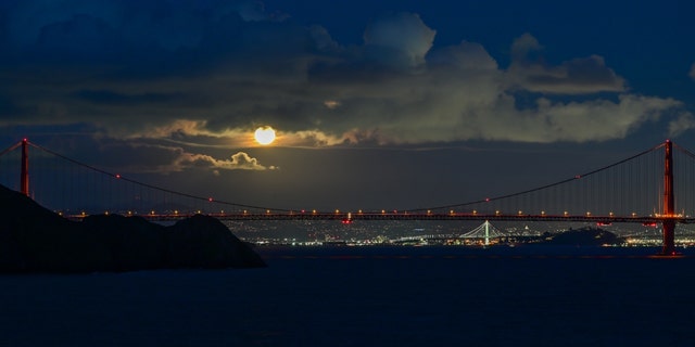 La pleine lune du ver s'élève au-dessus du Golden Gate Bridge à San Francisco, vue de Point Bonita à Sausalito, Californie, États-Unis, le 7 mars 2023. 