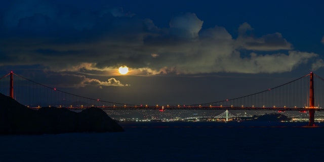 La pleine lune du ver s'élève au-dessus du Golden Gate Bridge à San Francisco, vue de Point Bonita à Sausalito, Californie, États-Unis, le 7 mars 2023.