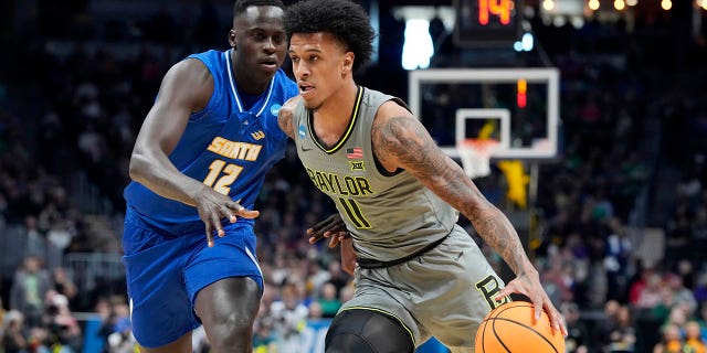 Baylor forward Jalen Bridges, front, drives past UC Santa Barbara forward Evans Kipruto in the first half of a first-round college basketball game in the men's NCAA Tournament, Friday, March 17, 2023, in Denver.
