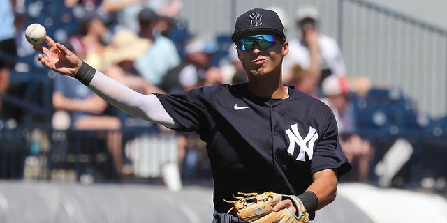 New York Yankees Infielder Anthony Volpe (77) throws the ball over to first base during the spring training game between the Minnesota Twins and the New York Yankees on March 24, 2023 at George M. Steinbrenner Field in Tampa, FL.
