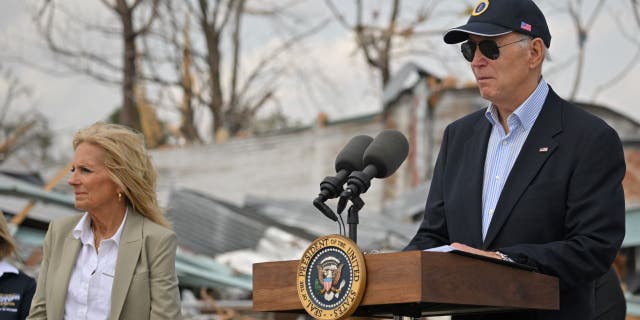 US President Joe Biden speaks successful Rolling Fork, Mississippi, connected March 31, 2023 arsenic First Lady Jill Biden (L) looks on.