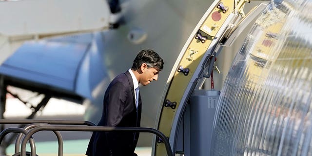 Britain's Prime Minister Rishi Sunak climbs the steps to his plane at the San Diego International Airport on March 13, 2023.