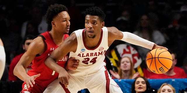 El alero de Alabama Brandon Miller (24) es protegido por el guardia de Maryland Jahmir Young (1) en la primera mitad de un partido de baloncesto universitario de segunda ronda del Torneo de la NCAA en Birmingham, Alabama, el sábado 18 de marzo de 2023. 
