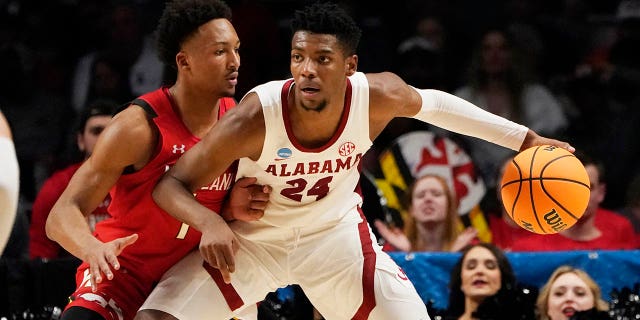 El alero de Alabama Brandon Miller (24) es protegido por el guardia de Maryland Jahmir Young (1) en la primera mitad de un partido de baloncesto universitario de segunda ronda del Torneo de la NCAA en Birmingham, Alabama, el sábado 18 de marzo de 2023. 