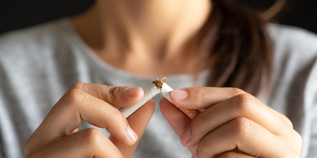 A woman destroying a cigarette.