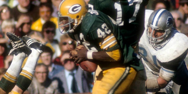 John Brockington de los Green Bay Packers agarra al mariscal de campo Jerry Tagge durante un juego contra los Detroit Lions en el Lambeau Field en Green Bay, Wisconsin, el 29 de septiembre de 1974.