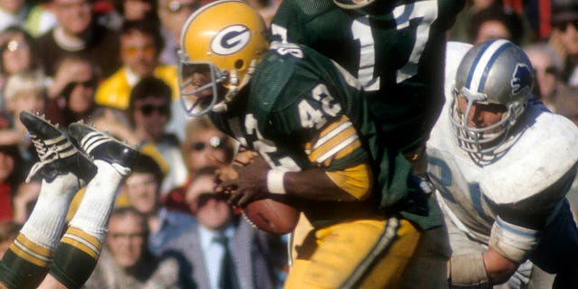 John Brockington de los Green Bay Packers agarra al mariscal de campo Jerry Tagge durante un juego contra los Detroit Lions en el Lambeau Field en Green Bay, Wisconsin, el 29 de septiembre de 1974.