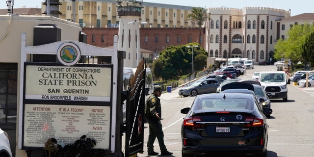 A guard checks vehicles entering the main gate at San Quentin State Prison on April 12, 2022, in San Quentin, California.