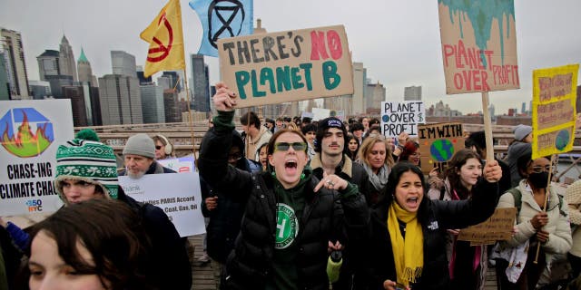 People walk through the Brooklyn Bridge during a strike for climate on March 03, 2023 in New York City. Protesters demand New York State support found and pass the Climate Jobs, and Justice Package. (Photo by Leonardo Munoz/VIEWpress/Corbis via Getty Images)