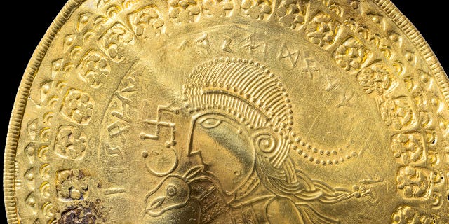 The inscription "He is Odin’s man" is seen over the head of a figure on a golden bracteate unearthed in Vindelev, Denmark, in late 2020.