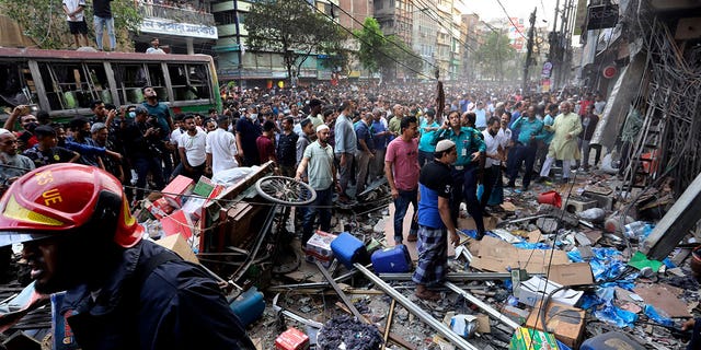 Spectators gather outside the site of an explosion, in Dhaka, Bangladesh on March 7, 2023. 