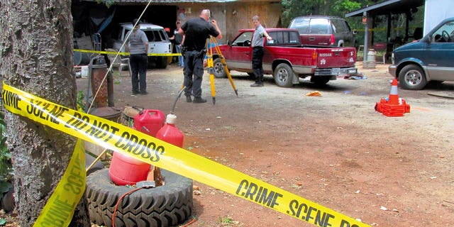 Investigators comb a property outside Wilderville, Oregon, on May 30, 2015, the morning after Oregon State Police troopers shot Robert Box. 