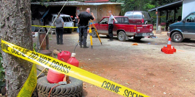 Investigators comb a property outside Wilderville, Oregon, on May 30, 2015, the morning after Oregon State Police troopers shot Robert Box.