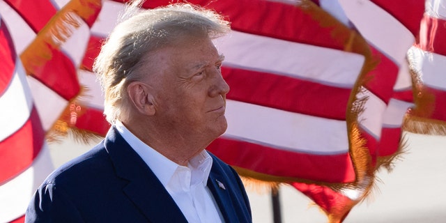 Former U.S. President Donald Trump with American flags in the background