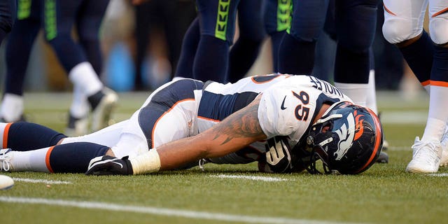 Denver Broncos defensive end Derek Wolfe (95) lies on the field motionless during an injury in the first quarter against the Seattle Seahawks August 17, 2013, at CenturyLink Field. He was taken to a local hospital and is evaluated for a cervical spine injury and has movement in all of his extremities.