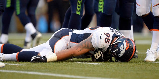 Denver Broncos defensive end Derek Wolfe (95) lies on the field motionless during an injury in the first quarter against the Seattle Seahawks August 17, 2013, at CenturyLink Field. He was taken to a local hospital and is evaluated for a cervical spine injury and has movement in all of his extremities.