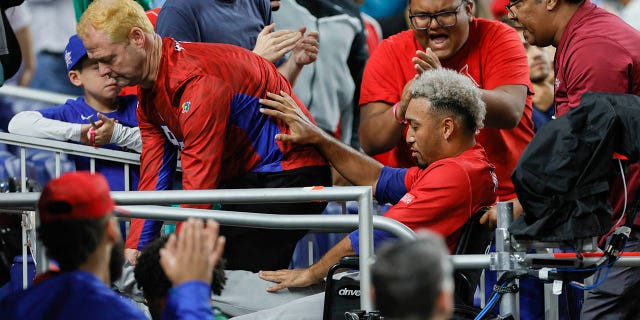 El lanzador puertorriqueño Edwin Díaz (39) sale del campo en silla de ruedas luego de una aparente lesión en la pierna durante la celebración del equipo contra República Dominicana en el LoanDepot Park.