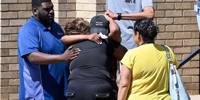 Parents comfort each other as they wait outside Woodmont Baptist Church for students from the Covenant School to arrive after a mass shooting at the school on Monday, March 27, 2023, in Nashville, Tennessee.