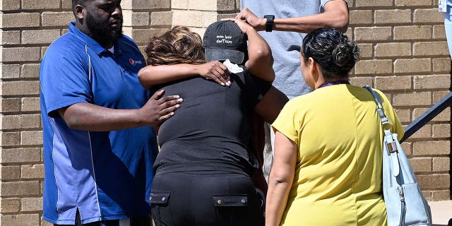 Parents comfort each other as they wait outside Woodmont Baptist Church for students from the Covenant School to arrive after a mass shooting at the school on Monday, March 27, 2023, in Nashville, Tennessee.