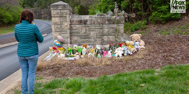 A mourner visits a memorial outside Covenant School for the six victims killed in a mass shooting in Nashville, Tennessee on Tuesday, March 28, 2023. On Monday, three adults and three children were killed inside the school.