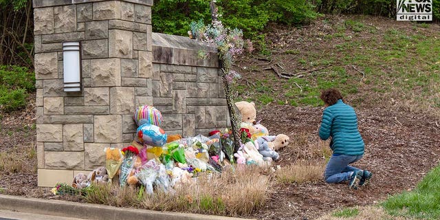 A mourner visits a memorial outside The Covenant School for the six victims who were killed in a mass shooting in Nashville, Tennessee, on Tuesday, March 28, 2023. On Monday, three adults and three children were killed inside the school.