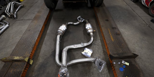 A catalytic converter sitting on the ground of a shop