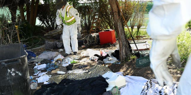 Work crews look over belongings left behind by a homeless person during clean-up in Echo Park.