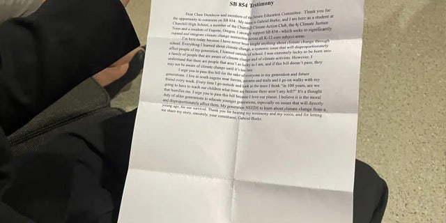 Mahasiswa tahun kedua sekolah menengah Gabriel Burke memegang salinan cetak kesaksiannya untuk mendukung RUU Oregon yang akan membutuhkan instruksi perubahan iklim di sekolah umum dari taman kanak-kanak hingga kelas 12, sebelum bersaksi dalam sidang di Capitol negara bagian di Salem, Ore., Kamis, 9 Maret 2023.