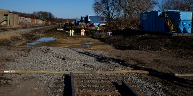 Ohio State Environmental Protection Agency and Federal Environmental Protection Agency contractors collect soil and air samples from the derailment site on March 9, 2023, in East Palestine, Ohio. 