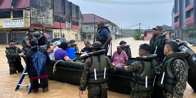 The army evacuates residents in southern Johor state, Malaysia, on March 1, 2023. Rescuers in boats helped flood victims trapped on rooftops as heavy rain submerged homes in parts of Malaysia.