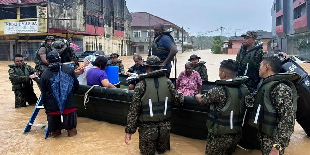 The army evacuates residents in southern Johor state, Malaysia, on March 1, 2023. Rescuers in boats helped flood victims trapped on rooftops as heavy rain submerged homes in parts of Malaysia.