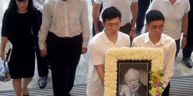 Late Prime Minister Lee Kuan Yew's family members arrive with his portrait at the state funeral in Singapore March 29, 2015. The brother of the current Singapore Prime Minister and son of the late Lee Kuan Yew accuses government authorities of harassing the his family.