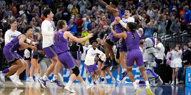 El escolta de Furman, JP Pegues, tercero desde la derecha, celebra con su equipo después de derrotar a Virginia en la primera ronda del Torneo de la NCAA, el jueves 16 de marzo de 2023 en Orlando.