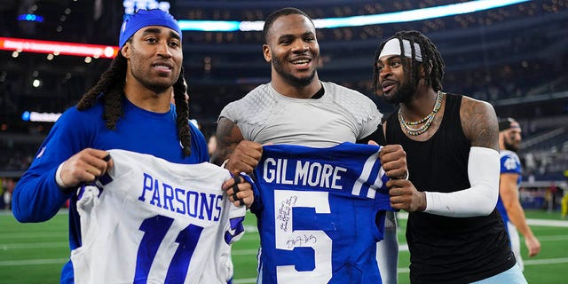 Micah Parsons, center, of the Dallas Cowboys, poses for a photo with Trevon Diggs, right, and Stephon Gilmore of the Indianapolis Colts at AT and T Stadium Dec. 4, 2022, in Arlington, Texas.