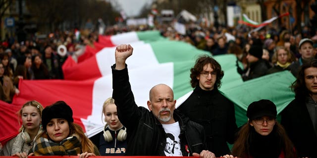 People carry a huge Hungarian flag during a march while calling for educational reforms in Budapest, Hungary, on March 15, 2023.